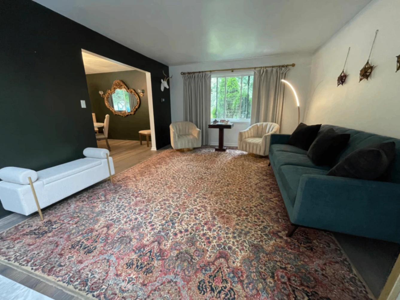 Parlor with seating, a rug, windows, and wall decor